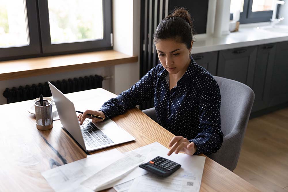 Business woman working at a desk, calculating taxes